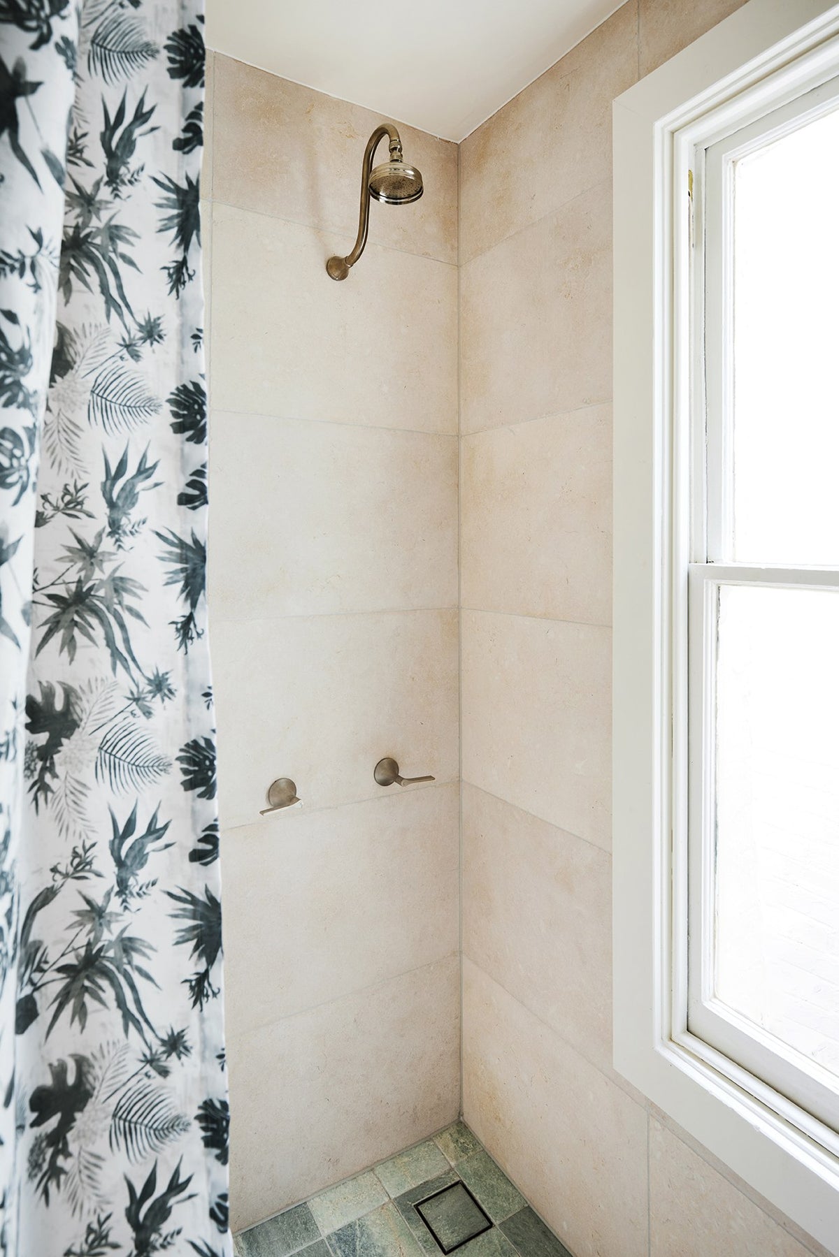 Boheme Paradise sage botanical shower curtain beside a stone shower, The Petite Pad