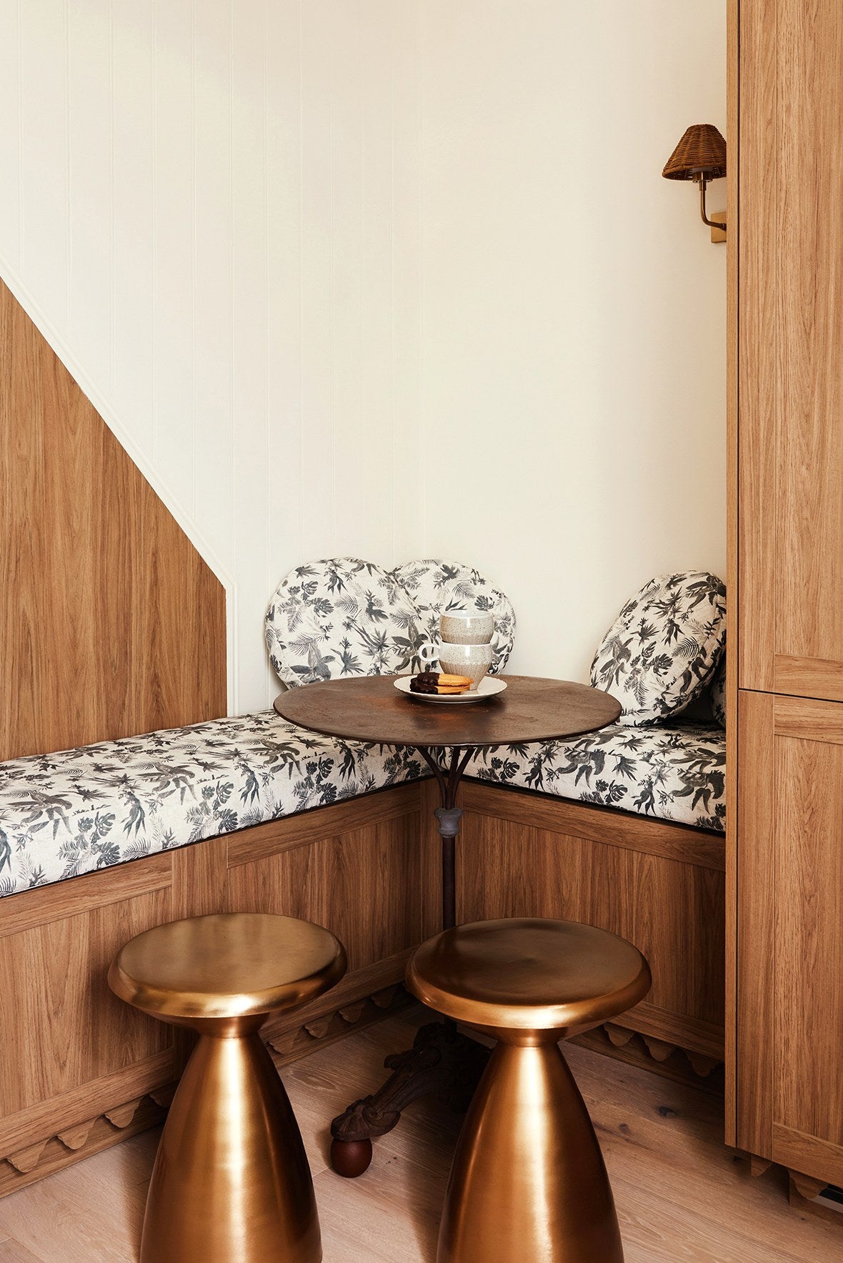 Kitchen nook banquette upholstered in Boheme Paradise fabric with brass stools