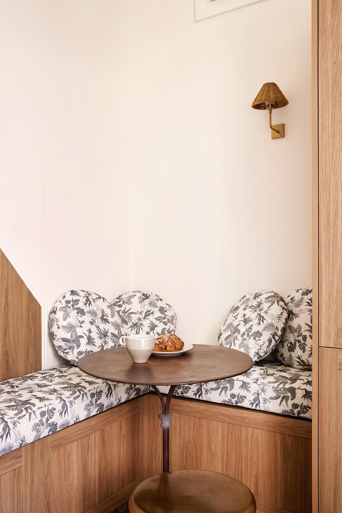 Round Boheme Paradise cushions on a banquette with coffee and a croissant