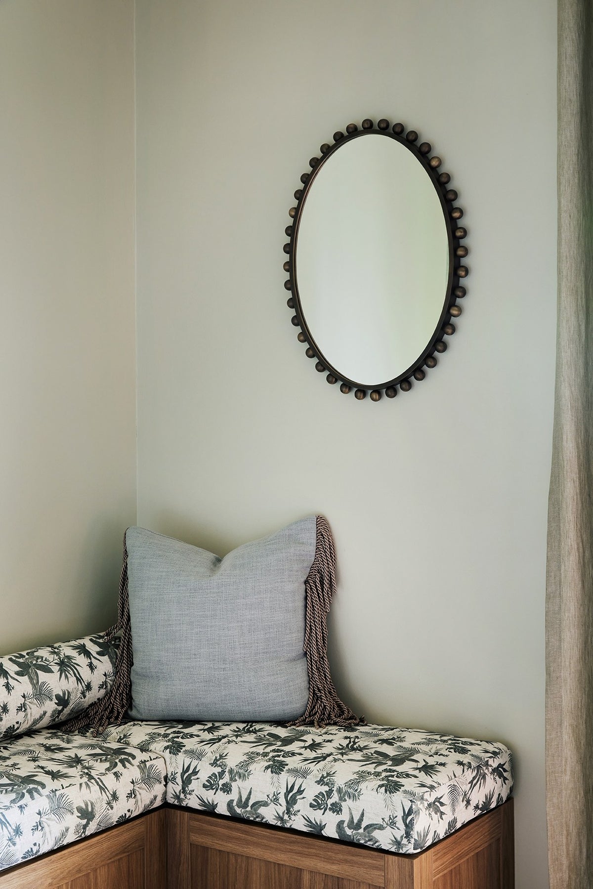 Boheme Paradise window seat cushion with an oval beaded mirror